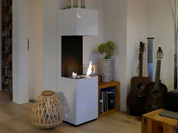 Open 3-sided white bioethanol fireplace lit in a cozy living room with a bookshelf and guitars